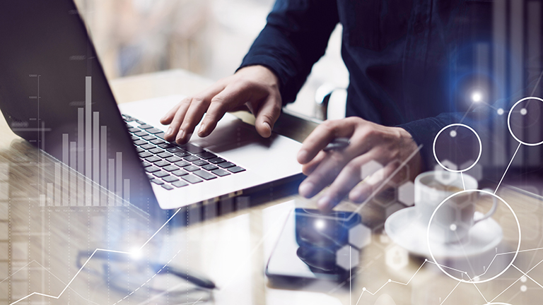 Concept of digital screen,virtual connection icon,diagram,graph interfaces.Businessman working at sunny office on laptop while sitting at the wooden table.Blurred background